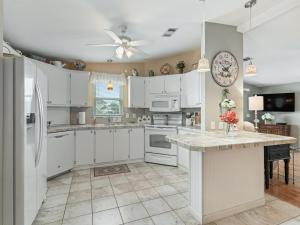 a kitchen with white cabinets and a large island at 1640 Z1 VILLAGE OF COUNTRY CLUB HILLS by REMAX Premier in The Villages +20 photos
