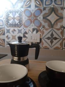 a coffee pot and two cups on a table at Freshwater Pirates CASA VALENTE in Gaeta