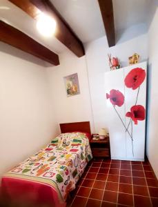 una camera da letto con un letto con fiori rossi sul muro di Maestro House on the Costa Dorada ad Alcanar