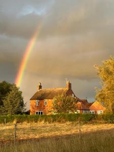 einen Regenbogen über einem Haus mit einem Haus in der Unterkunft Wellbet Farm in Lincoln