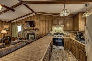 a kitchen with wooden cabinets and a large counter top at Pet Friendly Grizzly Blair Lodge Cabin in Groveland +20 photos