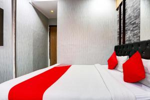 a bedroom with a large bed with red pillows at Hotel O Yatri Yadgar in Mumbai
