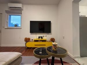 een woonkamer met een tv en een gele tafel bij Apartment Nino in Zadar