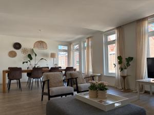 a living room with a table and a dining room at Heerlijke vakantiehuizen in Egmond in Egmond aan Zee