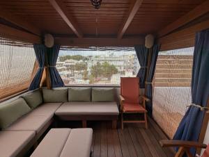 a couch and a chair in a room with a window at Panoramic deluxe penthouse in Thérissos