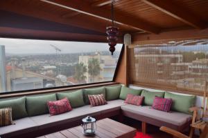 a balcony with a couch and a table and a window at Panoramic deluxe penthouse in Thérissos +5 photos