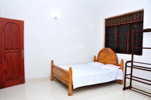 a small bedroom with a bed and a window at Anuradha Holiday Apartments in Anuradhapura
