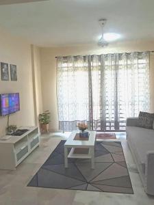 a living room with a couch and a table at d'Nur Homestay in Kampong Tanah Merah