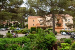 un bâtiment avec des voitures garées dans un parking dans l'établissement Chez Alain et Martine, à Saint-Mandrier-sur-Mer 11 autres photos