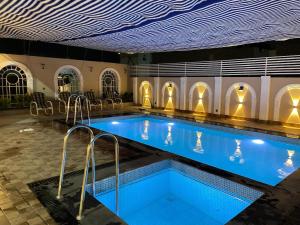 a large swimming pool with blue water in a building at ASNB Farm House 2BHK with Pool in Multan