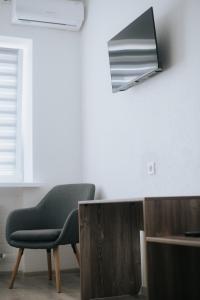 a chair sitting in a room next to a tv at 4ua-хостел in Bratslav