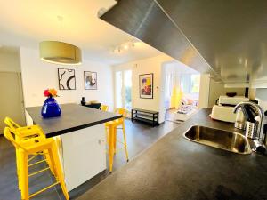 a kitchen with a sink and a kitchen with yellow stools at Pinède, calanques & jeux en famille pour 1 à 5 personnes in Cassis +47 photos