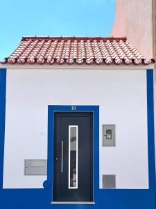 eine Tür an einem Gebäude mit einem roten Dach in der Unterkunft Oak House in Reguengos de Monsaraz