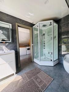 a bathroom with a glass shower and a sink at Suntau in Almaty