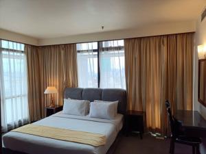 Una habitación de hotel con una cama, un escritorio y ventanas. en Rizstar Suite at Times square, en Kuala Lumpur 26 fotos más