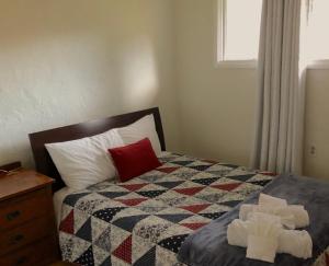 a bedroom with a bed with a quilt and a window at Raw Gold - Affordable, Near Mendenhall Glacier, Trails, and Conveniences - DISCOUNTS ON TOURS! in Mendenhaven