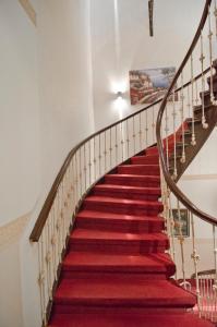 a red carpeted staircase in a house with a red rug at Hotel Polo am ZOB in Hamburg