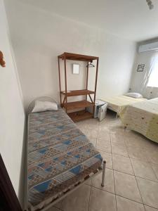 a room with two beds and a table in it at La Linda playa in Guaratuba