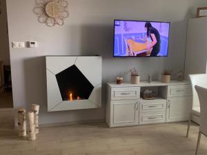 a living room with a fireplace and a flat screen tv at Apartament Świerkowa 11 in Augustów