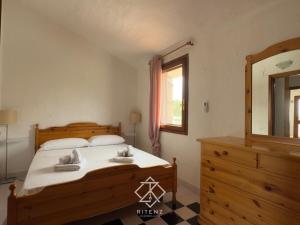 a bedroom with a bed and a mirror and a dresser at Domu Camelia - 300 meters from the sea in Porto Ottiolu