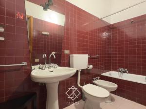 a red tiled bathroom with a sink and a toilet at Domu Camelia - 300 meters from the sea in Porto Ottiolu +21 photos
