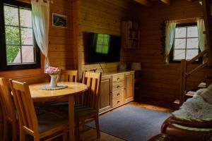 a dining room with a table and a television in a cabin at Borowa Chatka in Borowy Młyn