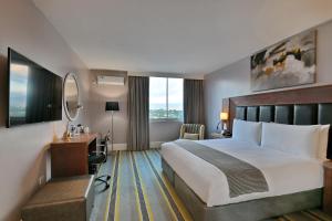 a hotel room with a bed and a desk at Holiday Inn - Mutare by IHG in Umtali +149 photos