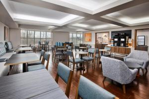 a restaurant with tables and chairs and windows at Holiday Inn Express Hotel & Suites Auburn Hills by IHG in Auburn Hills