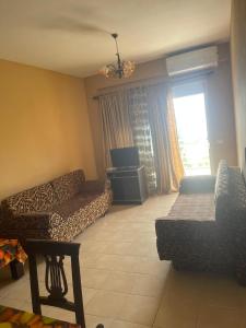 un soggiorno con divano, letto e finestra di Seaside Apartment Vlora a Vlorë