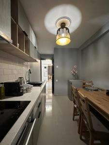 a large kitchen with a table and a light at Modis Apartment in Volos