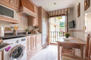 a kitchen with a washer and dryer at Luminoso apartamento en Liérganes in Liérganes