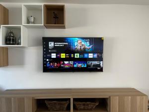 a flat screen tv hanging on a wall at Entire home in Gronant, United Kingdom in Talacre +10 photos