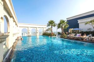 a large swimming pool in a building with people in it at Linda Apartment-ICON56-District4-3mins to center dtrc1- INFINITY POOL- AWESOME ROOFTOP in Ho Chi Minh City