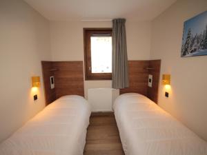 two beds in a room with a window at Charmant appartement neuf avec balcon, 2 chambres, 2 SDB et parking au cœur des Saisies - FR-1-293-272 in Hauteluce