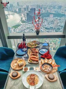 a table with plates of food on it with a view at Linda Apartment-ICON56-District4-3mins to center dtrc1- INFINITY POOL- AWESOME ROOFTOP in Ho Chi Minh City