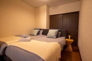 two beds in a hotel room with at BREEZE furano Annex205 in Furano