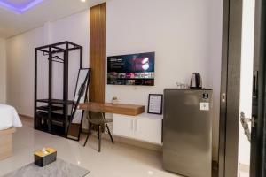 a room with a refrigerator and a desk in it at Homely Bali at Kayu Aya in Seminyak