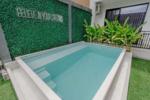 a swimming pool in the backyard of a house with plants at Homely Bali at Kayu Aya in Seminyak