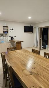 a dining room with a large wooden table and chairs at Departamentos Las Loicas in San Blás