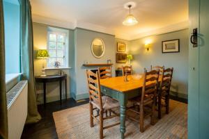 a dining room with a wooden table and chairs at Luxury 2 Bed Woodland Cottage on Rewilding Estate in Beaminster