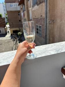 a person holding a glass of wine on a ledge at P&K apartment Pogradec in Pogradec