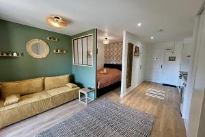 a living room with a couch and a bed at La Poulie - Apartment with Balcony and Free Privative Parking - Close to Colmar in Sainte-Croix-en-Plaine