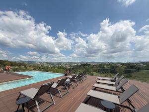 a row of chairs sitting on a deck next to a pool at Haven Nature Hotel & Villas in Batalha +115 photos