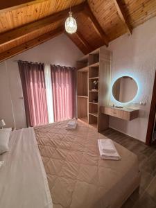 a bedroom with a large bed and a mirror at P&K apartment Pogradec in Pogradec