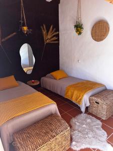a room with two beds and a mirror at Herdade da Maceira in São Luis
