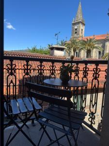 a table and chairs on a balcony with a church at Caldas no Camiño in Caldas de Reis
