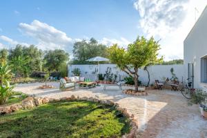 a patio with a tree and a table and chairs at La Casita Ostuni - Authentic Apulian Stay in Ostuni