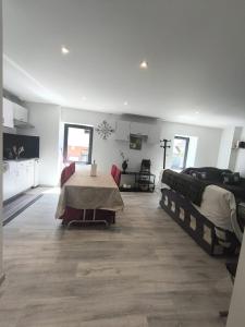 a living room with two beds and a table at Cosy et chaleureux, centre village, proche commodité in Champagne-en-Valromey