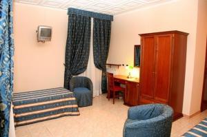una camera d'albergo con letto, scrivania e sedie di Hotel Nizza a Torino