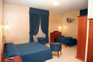 sypialnia z niebieskim łóżkiem i niebieskimi krzesłami w obiekcie Hotel Nizza w Turynie